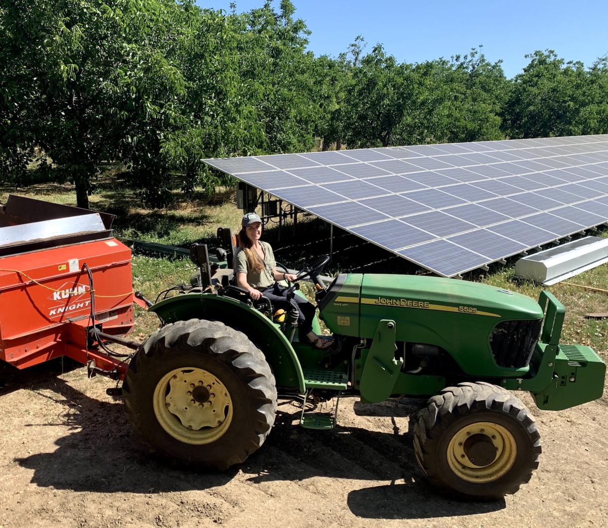 Emily McNamara in front of one of two solar arrays that offset her family farm’s energy use.